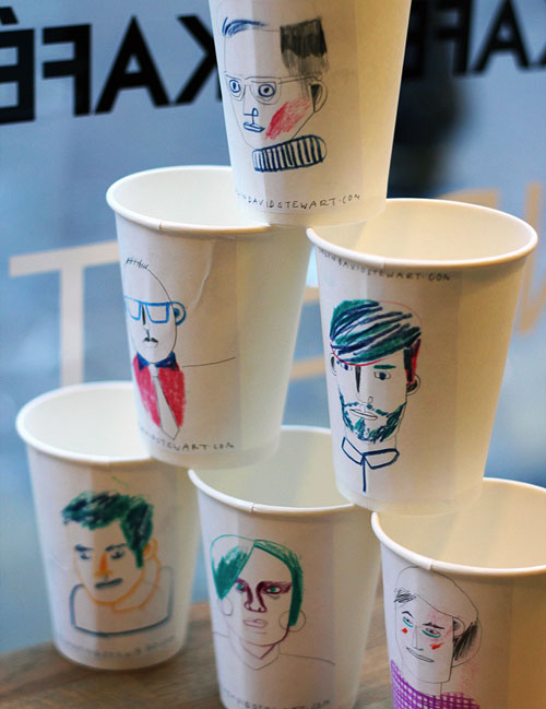 Six stacked cups with drawings of faces on them