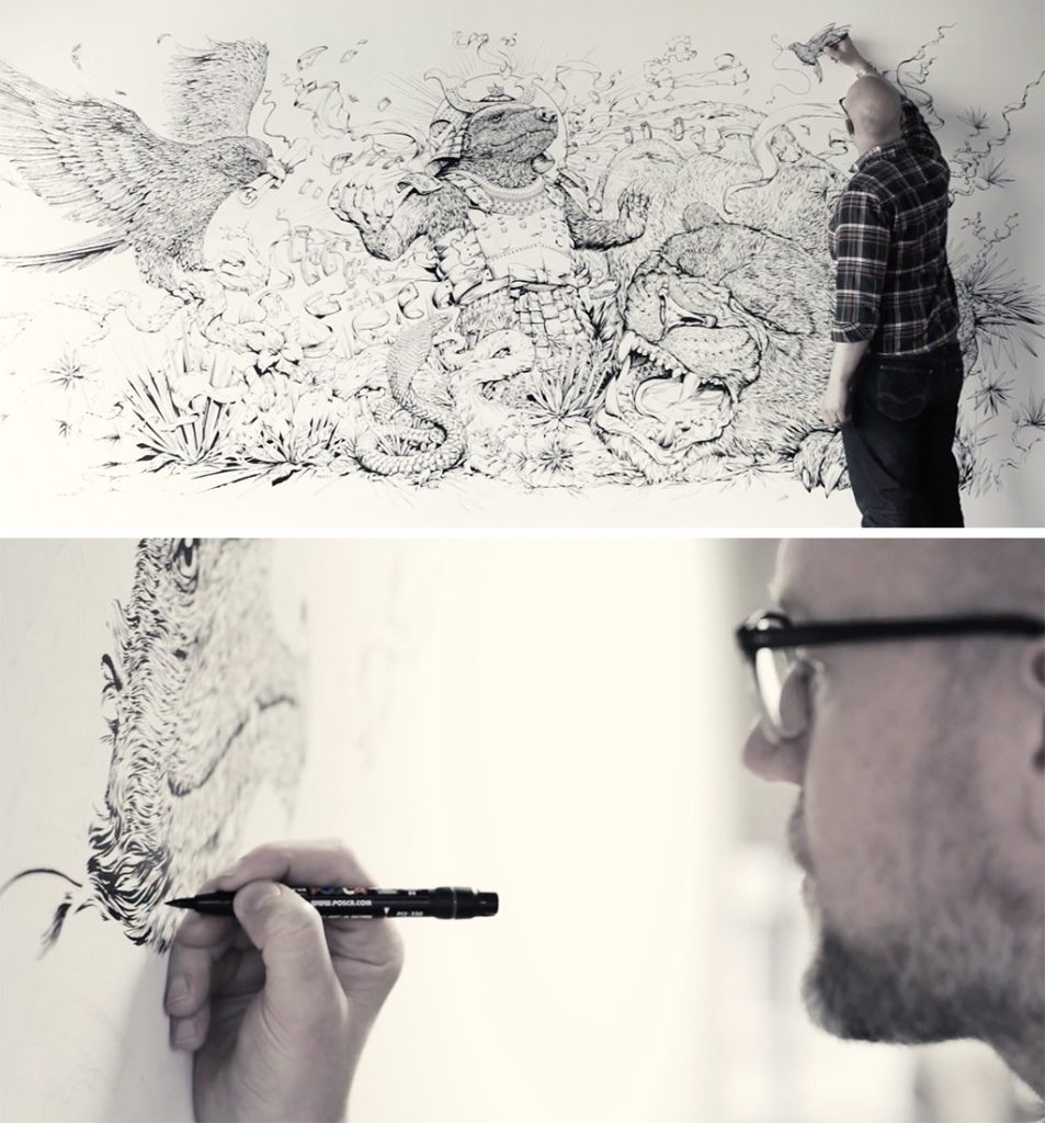 Man drawing a mural with a marker.